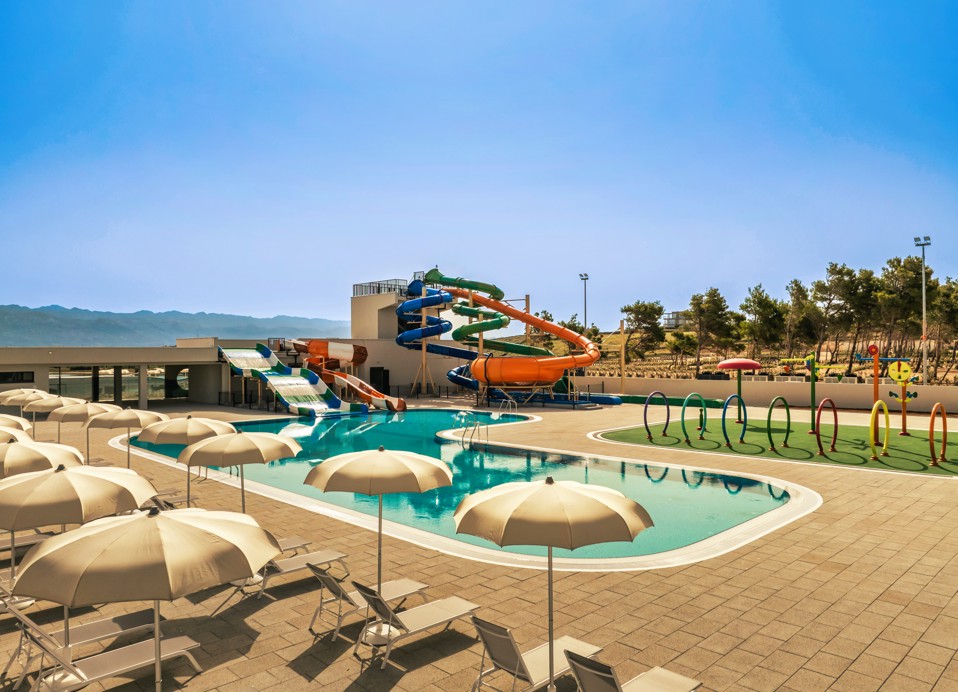 Liegestühle und Sonnenschirme neben dem Hauptpool im Aminess Style Camping Avalona Resort angeordnet.