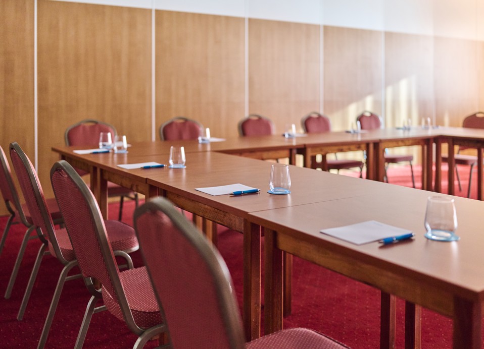 Configurazione del tavolo da riunione nella sala congressi presso l'Hotel Mediteran Maradiso di Aminess con bottiglie d'acqua e taccuini.