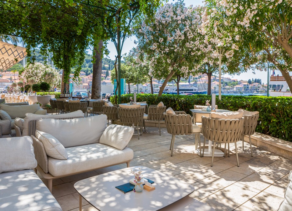Esterno del terrazzo del lounge bar G&T all'interno dell'Aminess Korcula Heritage Hotel, con eleganti e lussuosi divani lounge, rigogliosa vegetazione di piante mediterranee come l'oleandro.