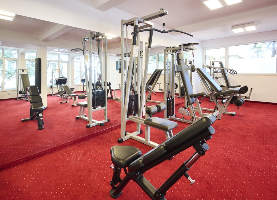 Potpuno opremljena teretana s velikim izborom sprava za trening snage i slobodnih utega u Aminess Younique Lume Hotelu.