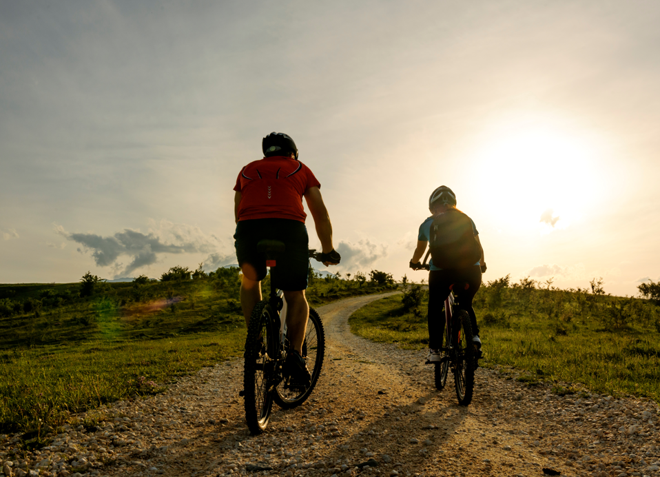Twee fietsers rijden tijdens zonsondergang op het eiland Krk in de buurt van Aminess Younique Gaia Green Villas