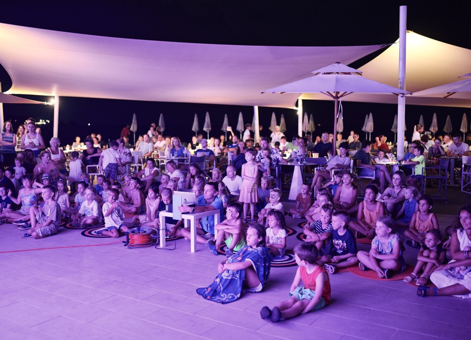 Otroci gledajo animacijsko predstavo v Aminess Planet Camping Sirena, Novigrad