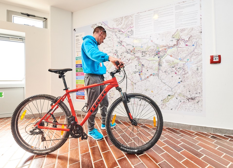 Un ciclista che guarda una mappa del sentiero.
