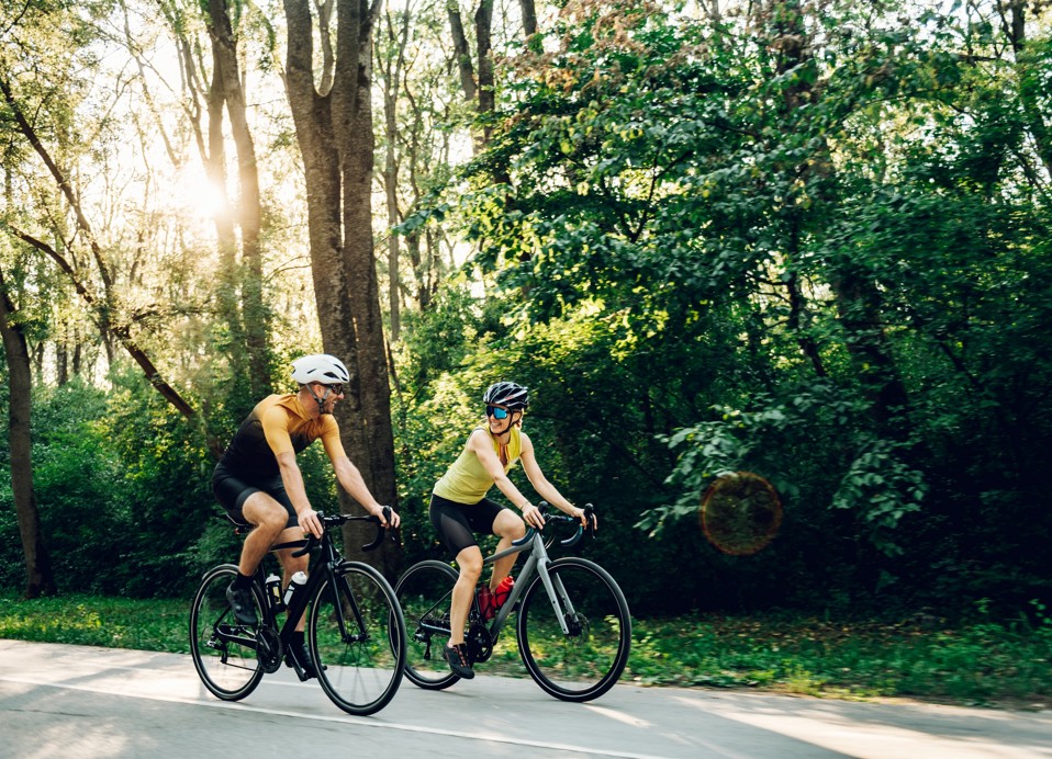 Two cyclists riding road bikes through the forest above Opatija