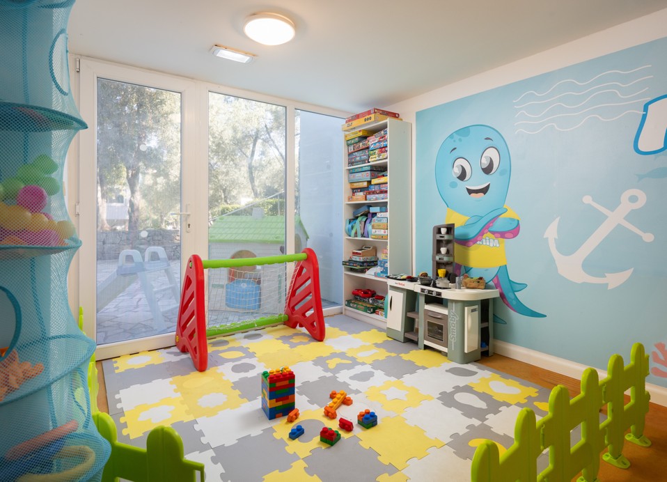 Spielzimmer im Miniclub des Aminess Vival Port9 Resorts mit Spielzeug und bunten Matten.