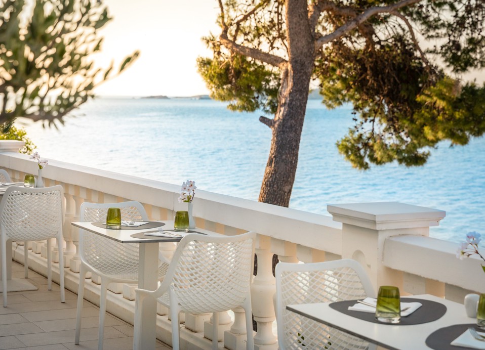 Restaurant terrace at Younique Bellevue Hotel with a sea view.