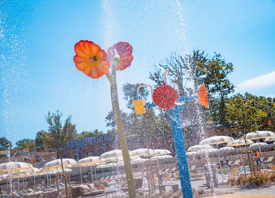 Area giochi d'acqua colorata con fiori e secchielli presso l'Aminess Style Camping Atea Resort.