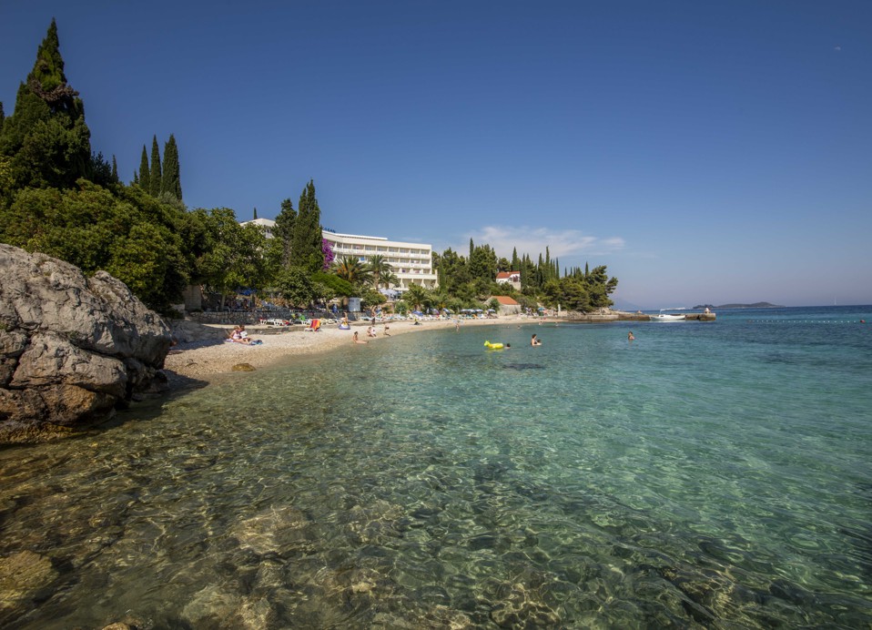 Una pittoresca spiaggia con palme vicino a Maradiso Orsan by Aminess Hotel.
