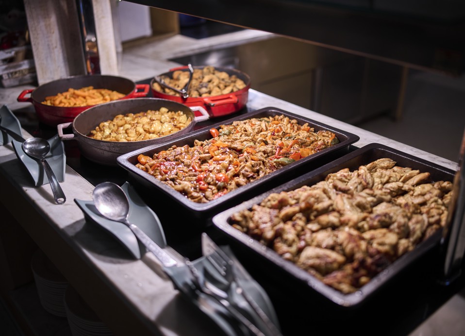 Topla jedila na bifeju hotela Aminess Lišanj, postrežena v posodah za hrano.