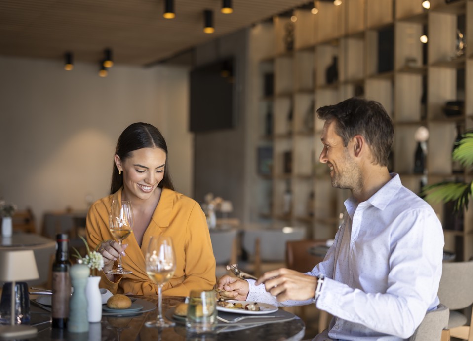 Couple dining indoors at Half8 restaurant at Aminess Younique Narrivi Hotel.