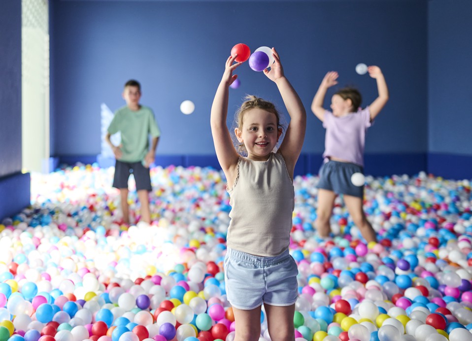 Kinderen spelen en gooien ballen in een kleurrijk ballenbad in de speelruimte