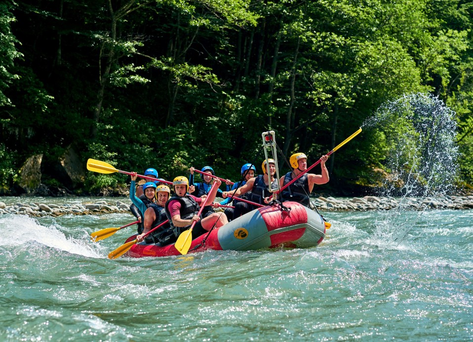 Group rafting on a river surrounded by dense green forest near Karlovac.