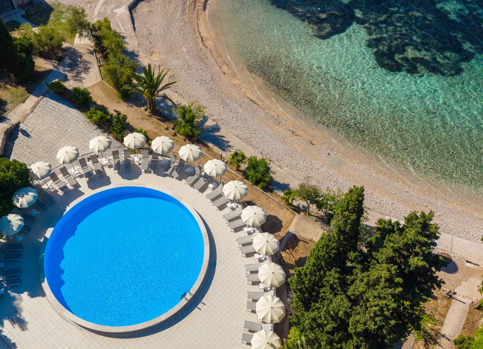 Luftaufnahme des Pools im Orsan Maradiso Hotel by Aminess neben Strand und klarem Meer.