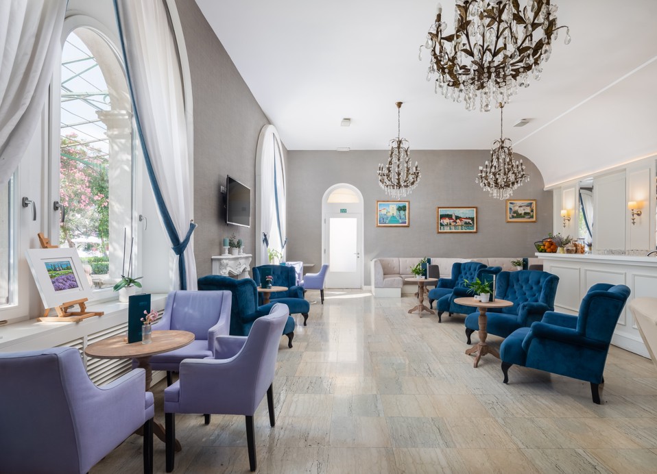 Interno del G&T lounge bar all'interno dell'Aminess Korcula Heritage Hotel, con un elegante arredamento in blu e grigio e poltrone lounge blu.