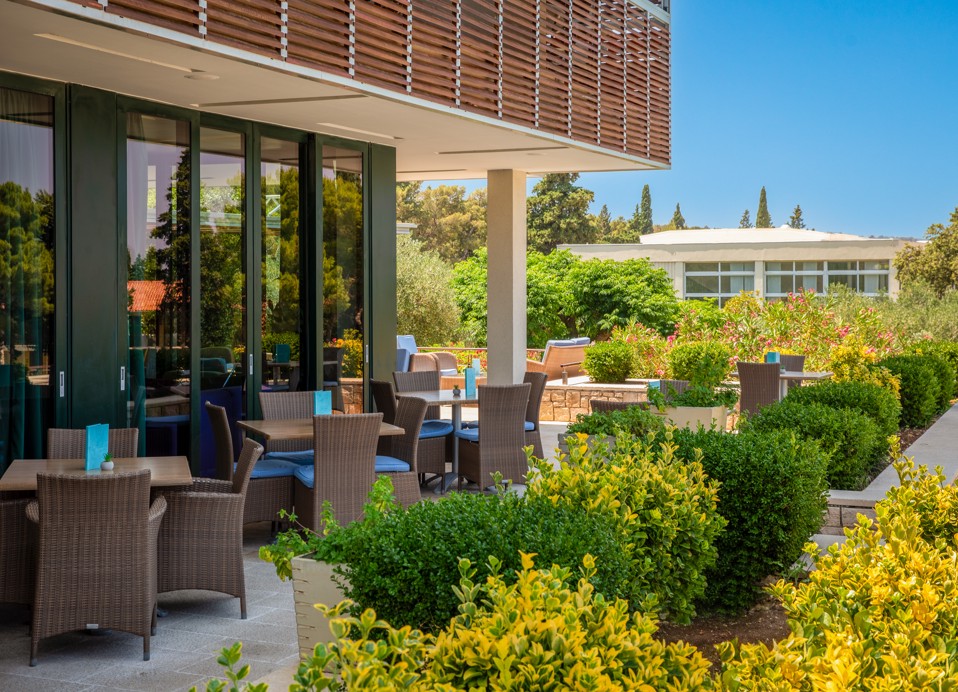 Zunanji del lobby bara v letovišču Aminess Vival Velaris na Braču, obdan z mediteranskim rastlinjem