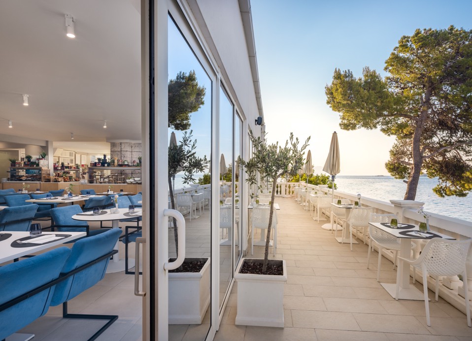Unico restaurant at Younique Bellevue Hotel opens onto a terrace with a sea view.