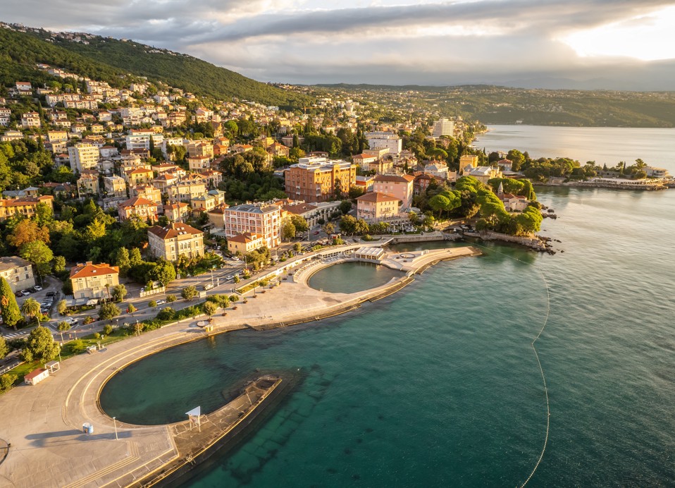 Aerial view of Opatija with historic villas, seaside promenade and the calm Kvarner Sea glowing in the warm light of sunset