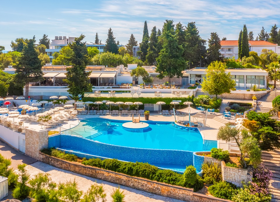 Luftaufnahme des Pools im Aminess Vival Port9 Resort, umgeben von Grünflächen und modernen Annehmlichkeiten auf der Insel Korčula.