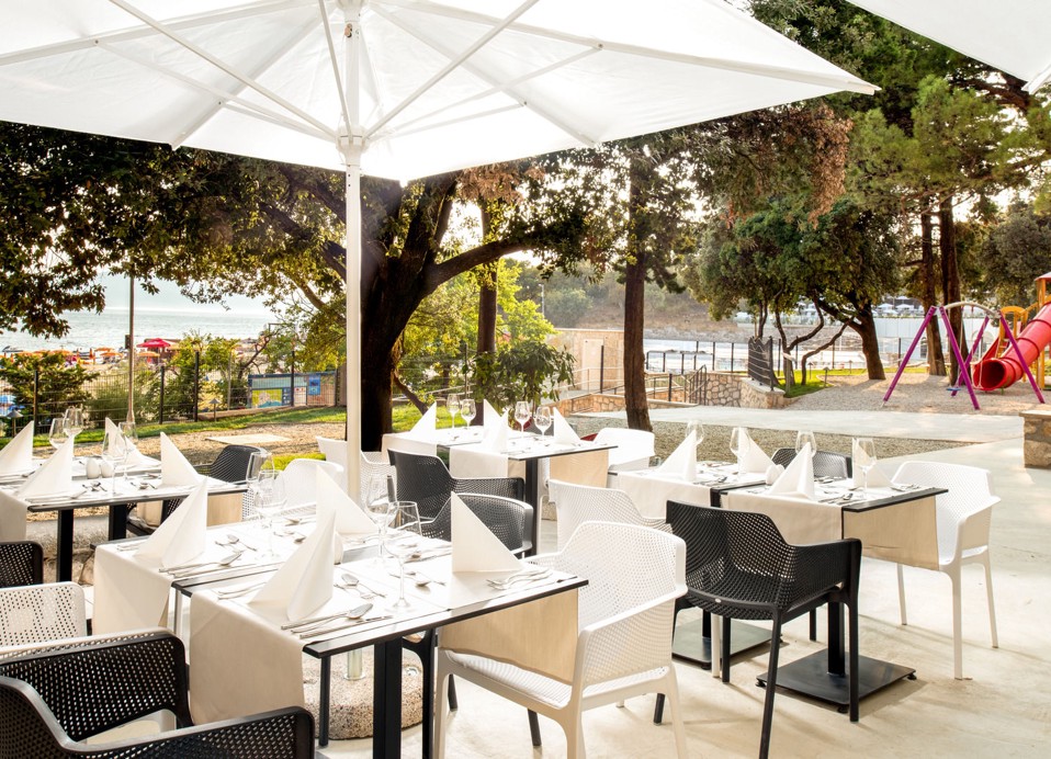 Aminess Vival Lišanj Family Hotel zunanja terasa restavracije s senčenimi sedeži, obdana z zelenjem in družinam prijazno atmosfero v Novem Vinodolskem.