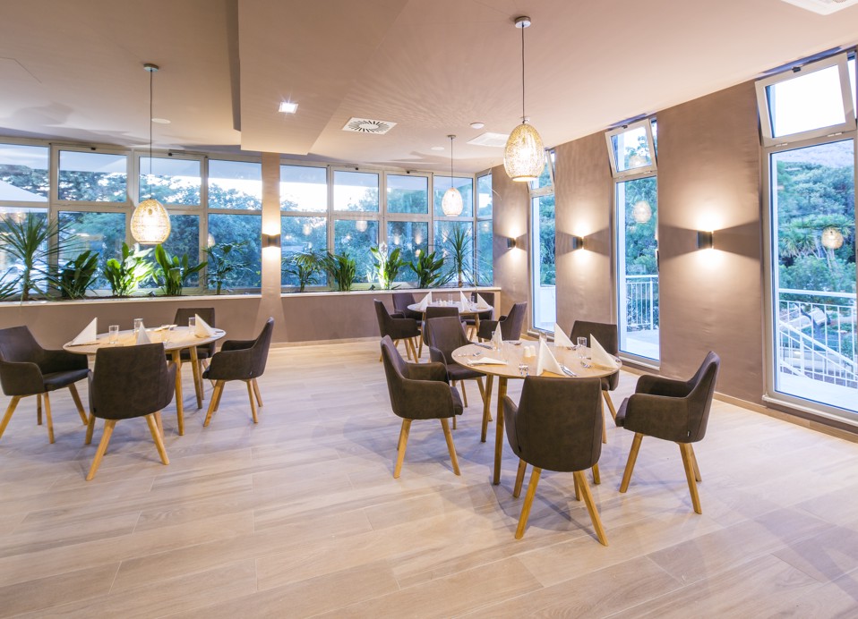 Tische für das Essen aufgestellt, bereit, Gäste in gemütlichem, modernem Interieur im Aminess Vival Port9 Resort in Korcula willkommen zu heißen.