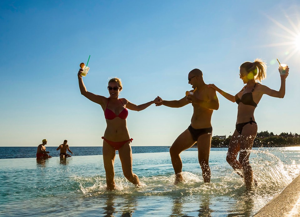 Prijatelji plešu u bazenu s pićima u rukama u Aminess Maradiso Hotel Laguna, Novigrad Hrvatska