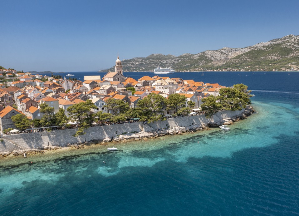Panoramiczny widok na stare miasto Korčula z kamiennymi murami, turkusowym morzem i charakterystyczną wyspiarską architekturą