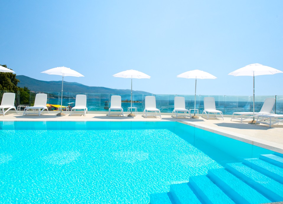 Aminess Vival Lišanj Familienhotel Außenpool mit Meerblick, umgeben von weißen Sonnenschirmen und Liegestühlen.