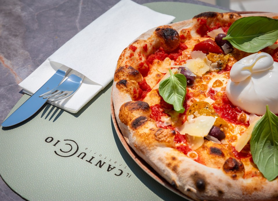 Pizza with burrata and basil on a table at Il Cantuccio restaurant