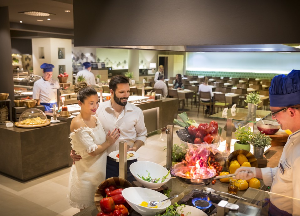 Een stel geniet van de live kookervaring in het restaurant.