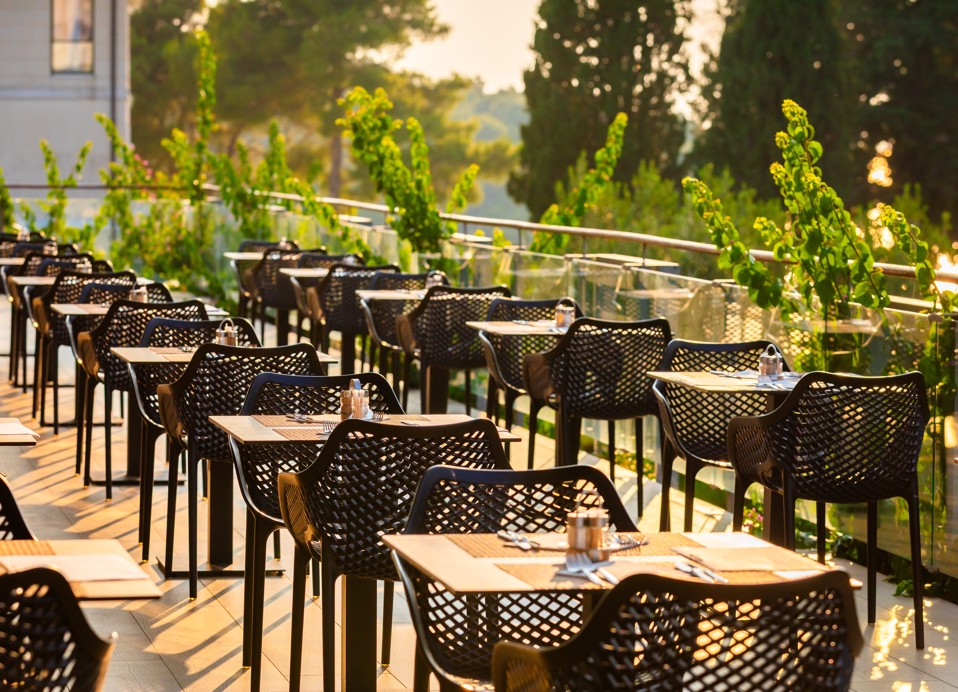 Terasa restavracije Oliveto s pripravljenimi mizami in pogledom na zelenje, Aminess Vival Velaris Resort, Brač