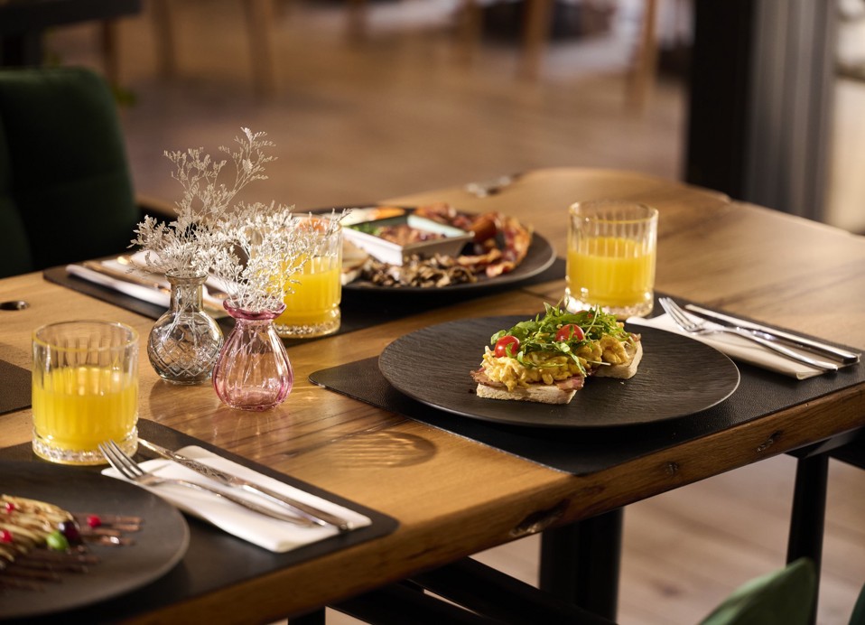 Breakfast table with eggs and orange juice at Aminess Kadoor Hotel.