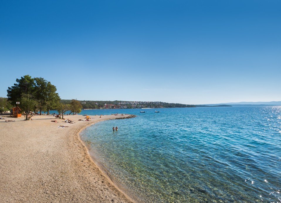 Spiaggia vicino ad Aminess Younique Gaia Green Villas con acqua limpida e riva sabbiosa.