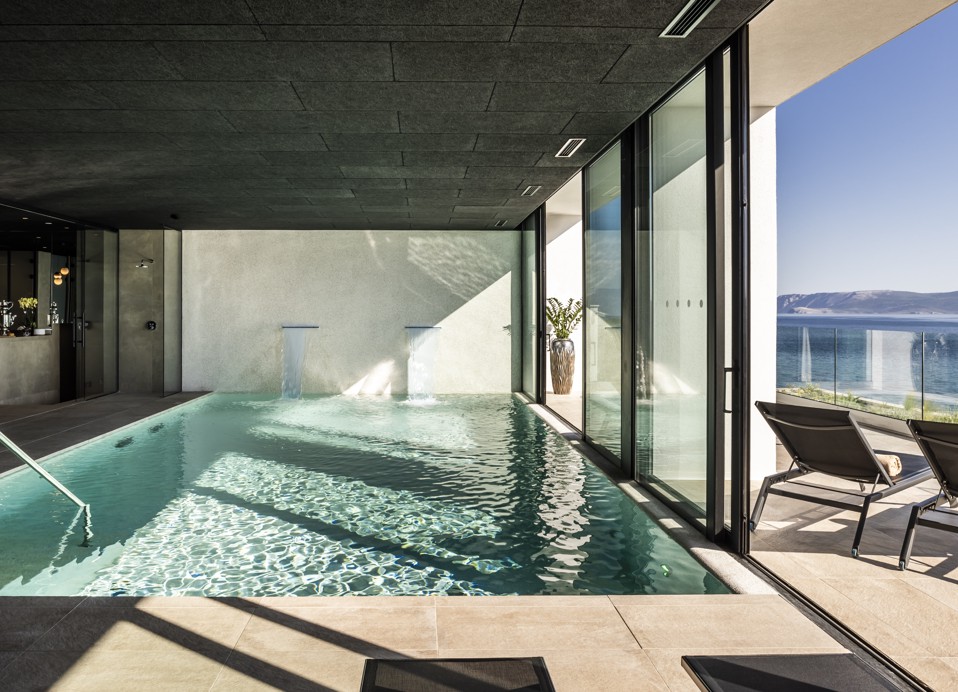 Lettini relax vicino alla piscina interna con vista sul mare presso l'hotel Aminess Younique Narrivi.