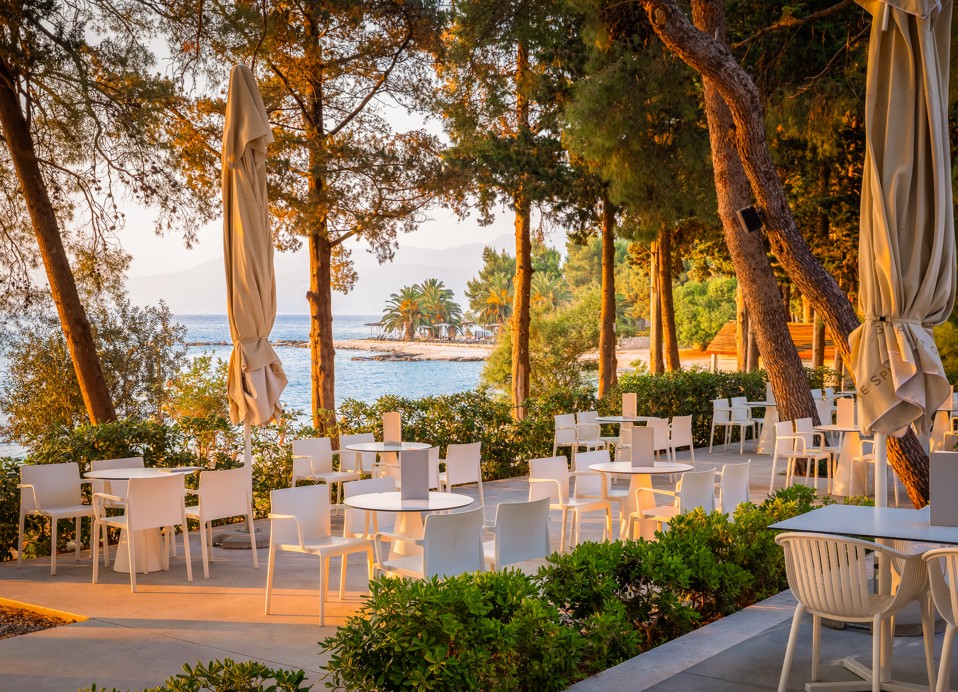 Zunanji bar Punto Mare v letovišču Aminess Vival Velaris na Braču, obdan z borovci s pogledom na morje