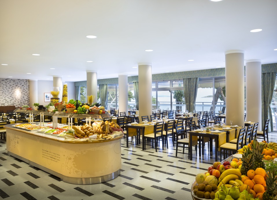 Ein Buffet-Restaurant mit Tischen und bunten Obst- und Essensarrangements auf den Theken im Aminess Vival Grand Azur Hotel.