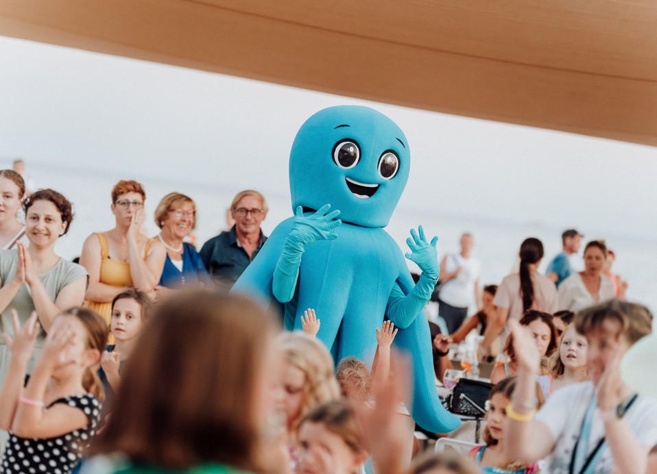 I bambini ballano con una mascotte durante l'animazione all'Aminess Khalani Hotel.