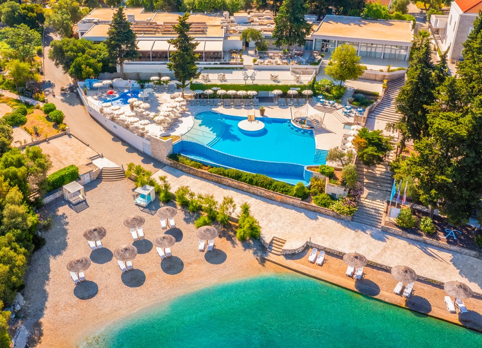 Luftaufnahme des Pools im Aminess Vival Port9 Resort, umgeben von Grünflächen und modernen Annehmlichkeiten auf der Insel Korčula.