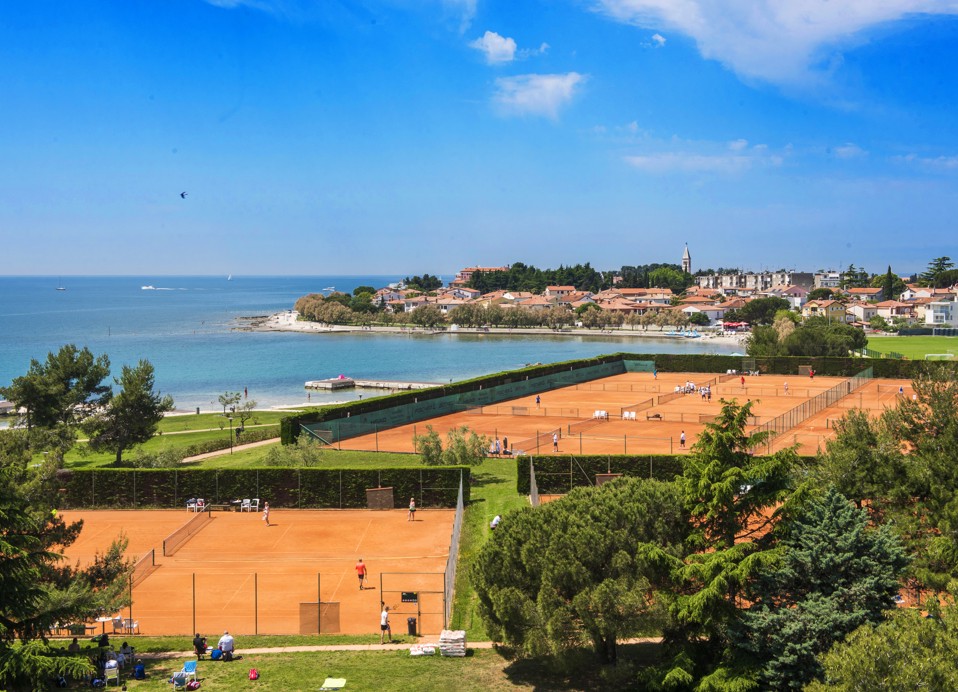L'immagine mostra giocatori su due campi da tennis con il mare sullo sfondo e una vista di Novigrad.