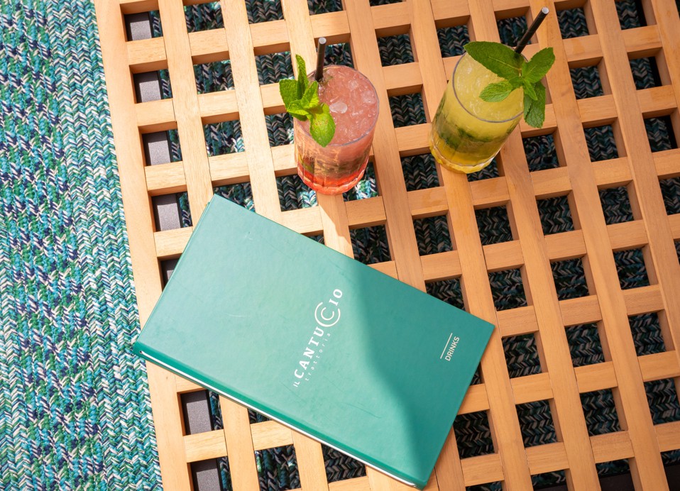 Two cocktails and the Il Cantuccio menu on a wooden table