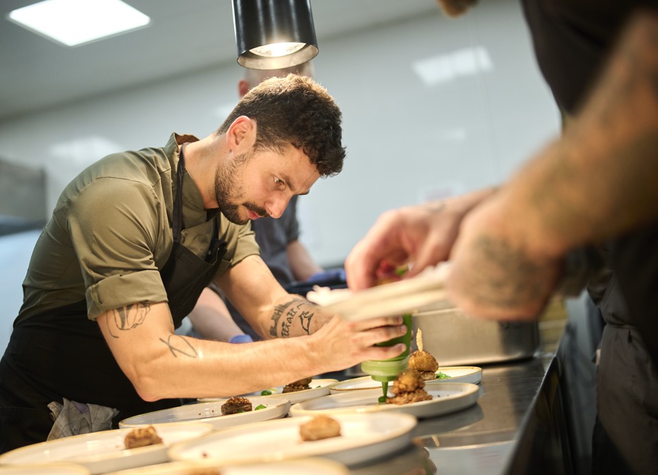 Kuhar Matija Bogdan pripravlja gurmansko jed v kuhinji restavracije in bara 7 Seas blizu Aminess Style Camping Atea Resort.