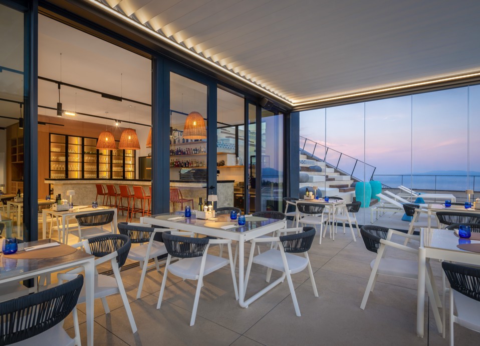 Il Cantuccio restaurant at dusk with set tables and a sea view