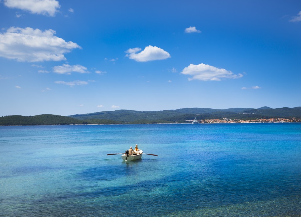 Gost se opušta na dasci za veslanje na plaži blizu Aminess Maradiso Casa Bellevue.