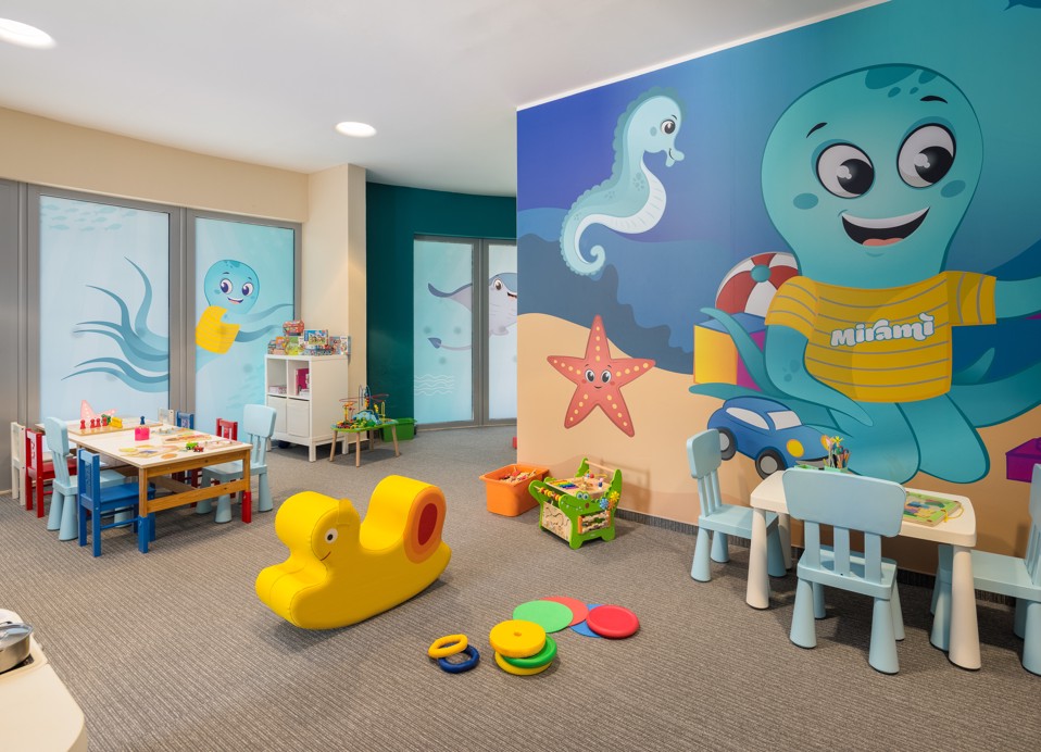 Miniclub-Spielzimmer im Aminess Vival Grand Azur Hotel mit Oktopus-Wandbild und Spielzeug.