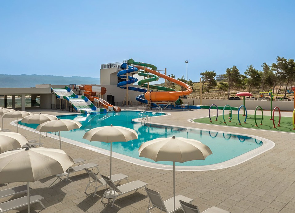 Ligstoelen en parasols gerangschikt naast het hoofdzwembad bij het Aminess Style Camping Avalona resort.