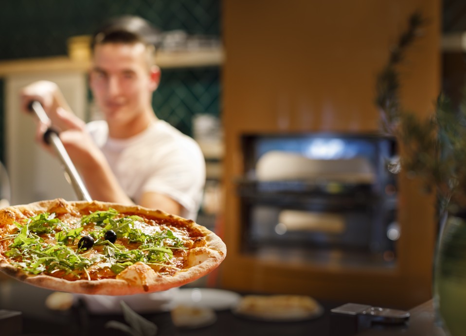 Koch bereitet eine Pizza in einer Pizzeria im Aminess Planet Camping Maravea, Novigrad zu