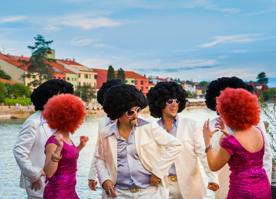 Gasten gekleed in levendige kostuums genieten van een thema-evenement in het Veya Maradiso Hotel by Aminess.