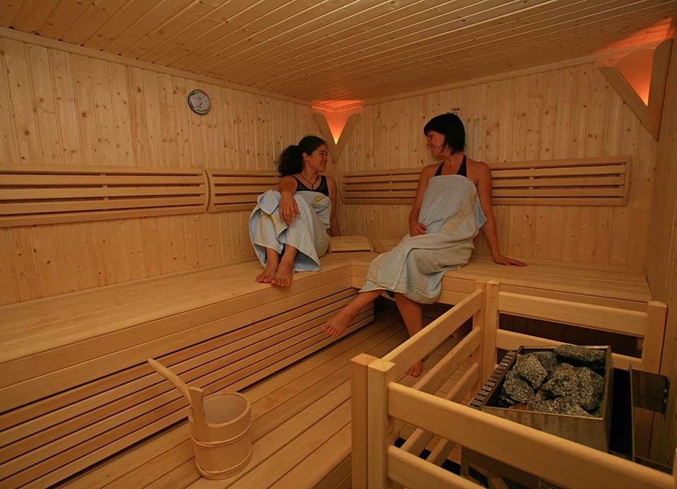 Guests enjoying a cozy sauna, seated on wooden benches in a tranquil wellness area focused on relaxation and rejuvenation at the Maradiso Marko Polo by Aminess.