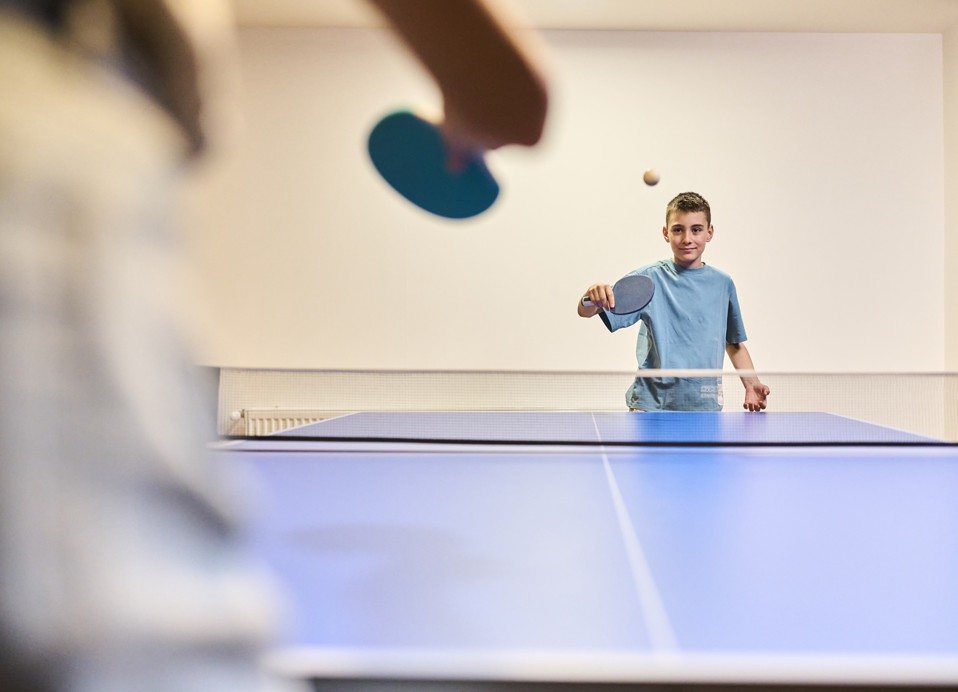 Jongens spelen tafeltennis in de speelruimte van het hotel