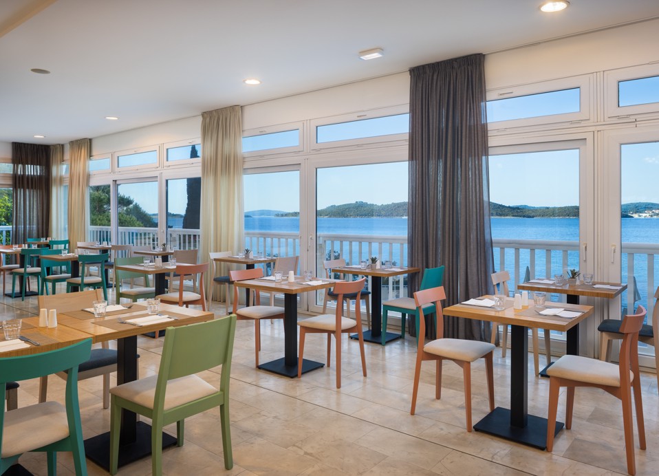 Restaurant at Orsan Maradiso Hotel by Aminess with sea views and set tables.