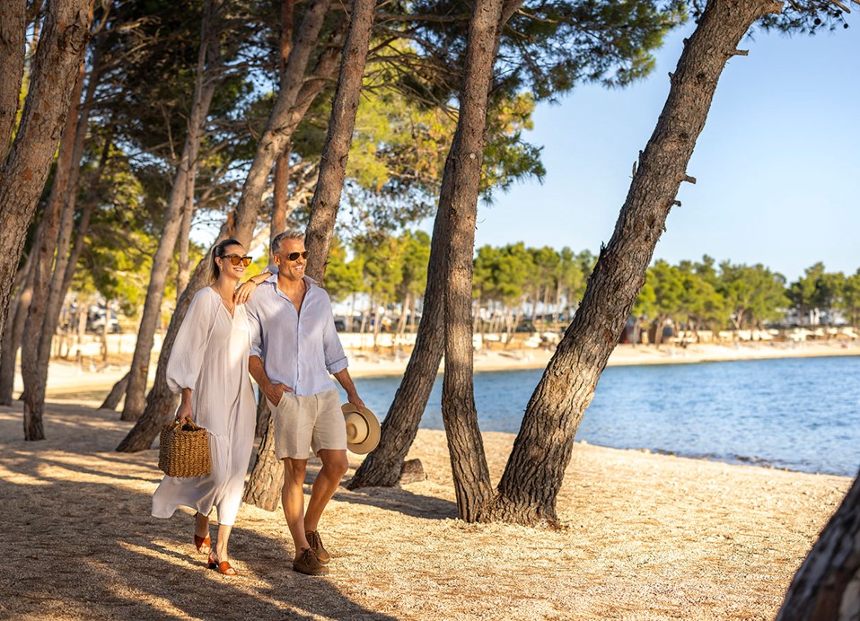 Paar spaziert am Strand im Aminess Style Camping Avalona Resort.